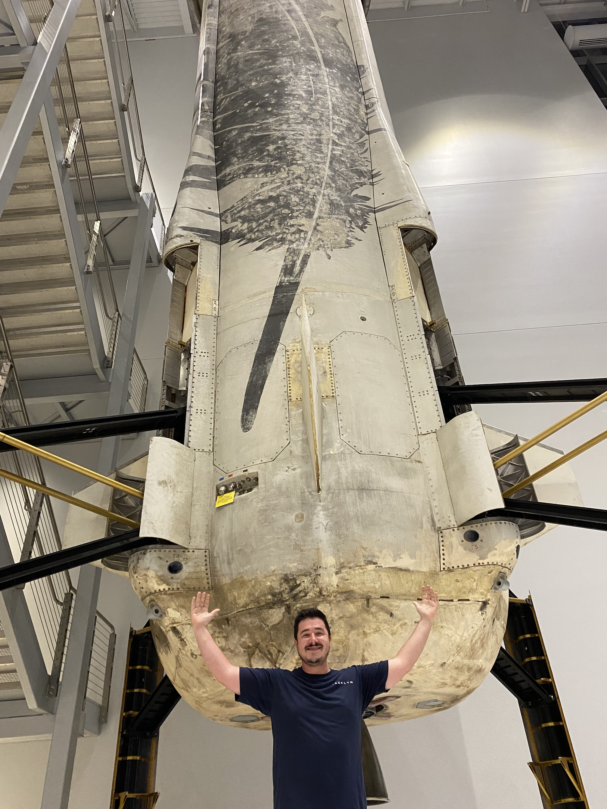 ARCS Scholar Samuel Buckner poses in front of a previously flown New Shepard rocket booster 