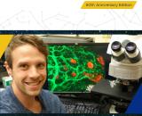 Picture of the front cover of the Annual Report Celebrating the Past, Envisioning the Future. Picture includes a smiling man in front of a workstation in a laboratory